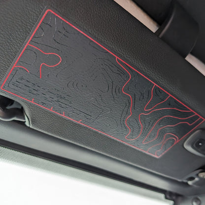 Car interior with a sun visor featuring red design on a black background